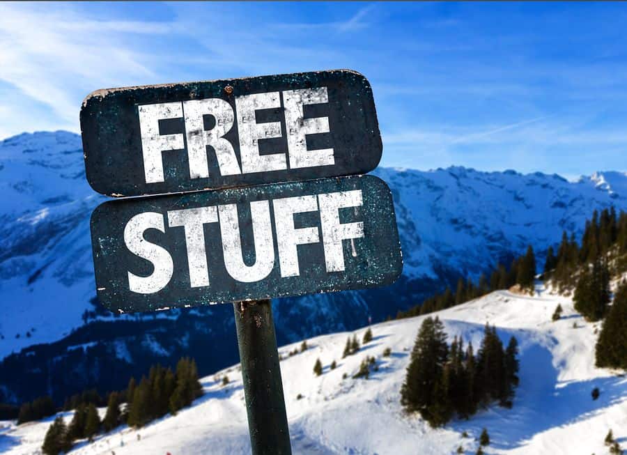 A frosty sign says “Free Stuff” against a snowy mountain backdrop.