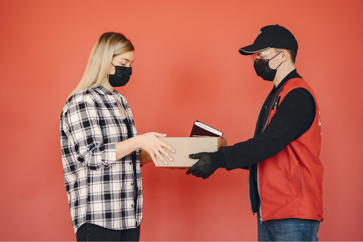 A delivery man handing a boss to a customer. 